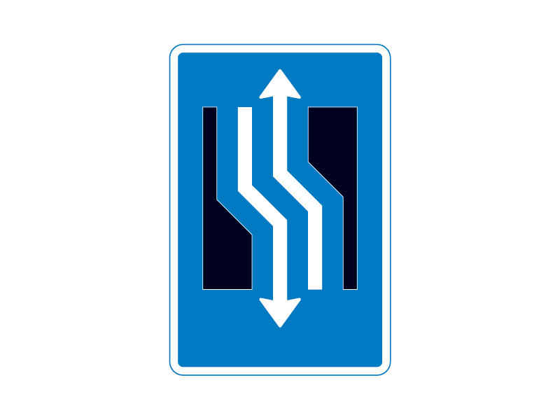 Færdselstavle E16.3.13 viser et vognbaneforløb, hvor kørebanen forsætter til venstre, og den indikerer en markant retningsændring på vejen, men advarer samtidig om, at der er modkørende trafik i samme område.